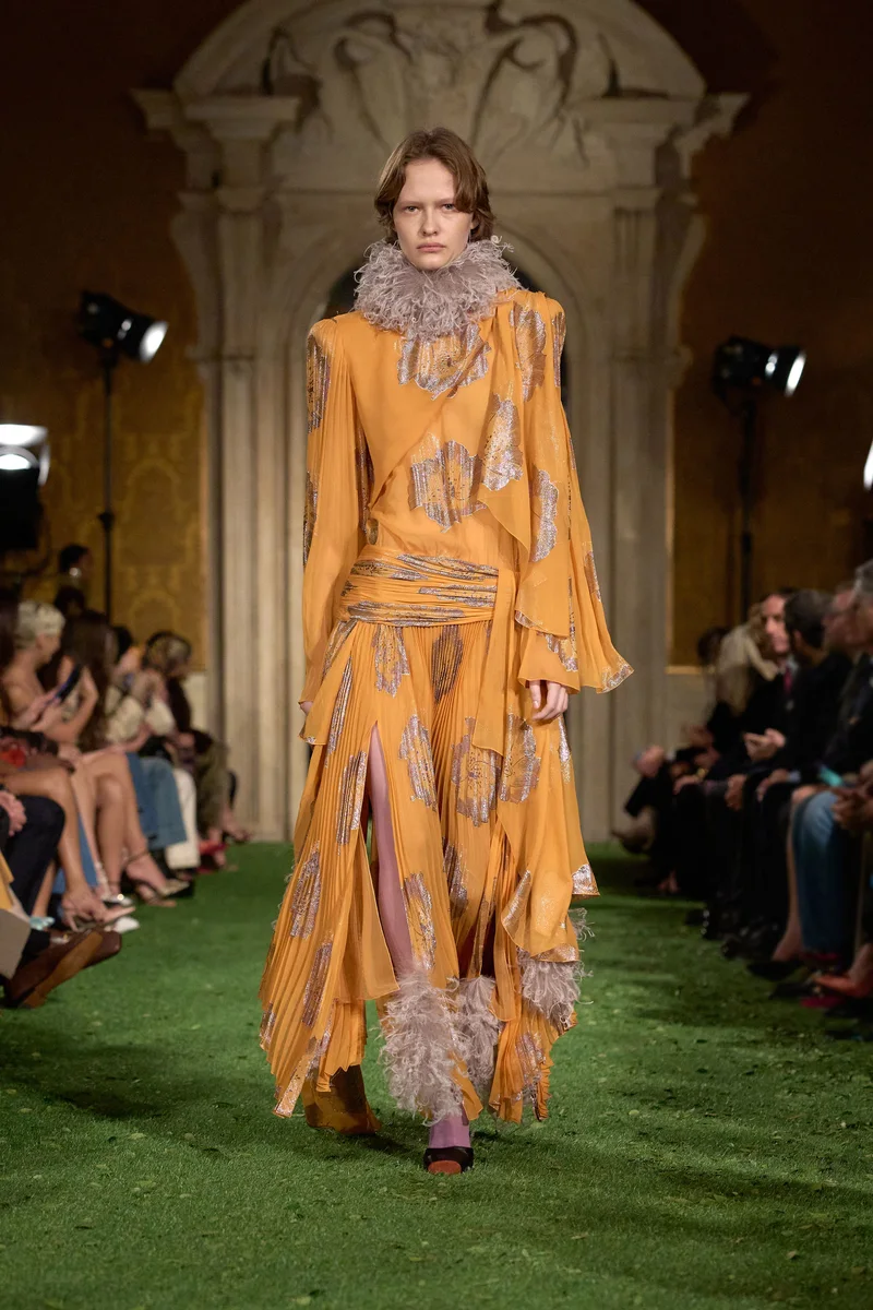 Модель Valentino в оранжевом платье с принтом и воротником из перьев