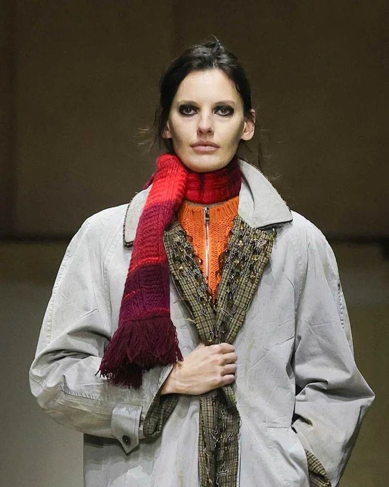 Бордово-красный вязаный шарф с бахромой поверх серого пальто, Prada осень-зима 2026-2027