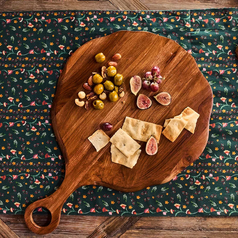 Круглая деревянная доска с оливками, инжиром, крекерами и кусочками сыра